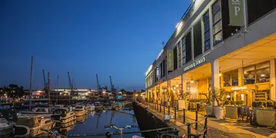 Quiet Bristol harbour at night to illustrate economic impact and financial recovery